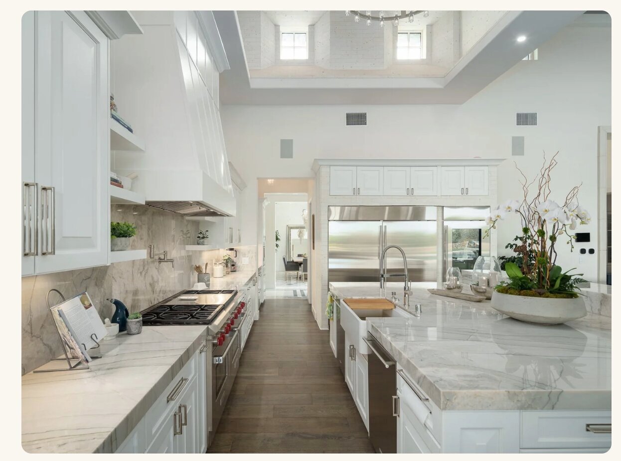 White marble kitchen with high ceilings and island